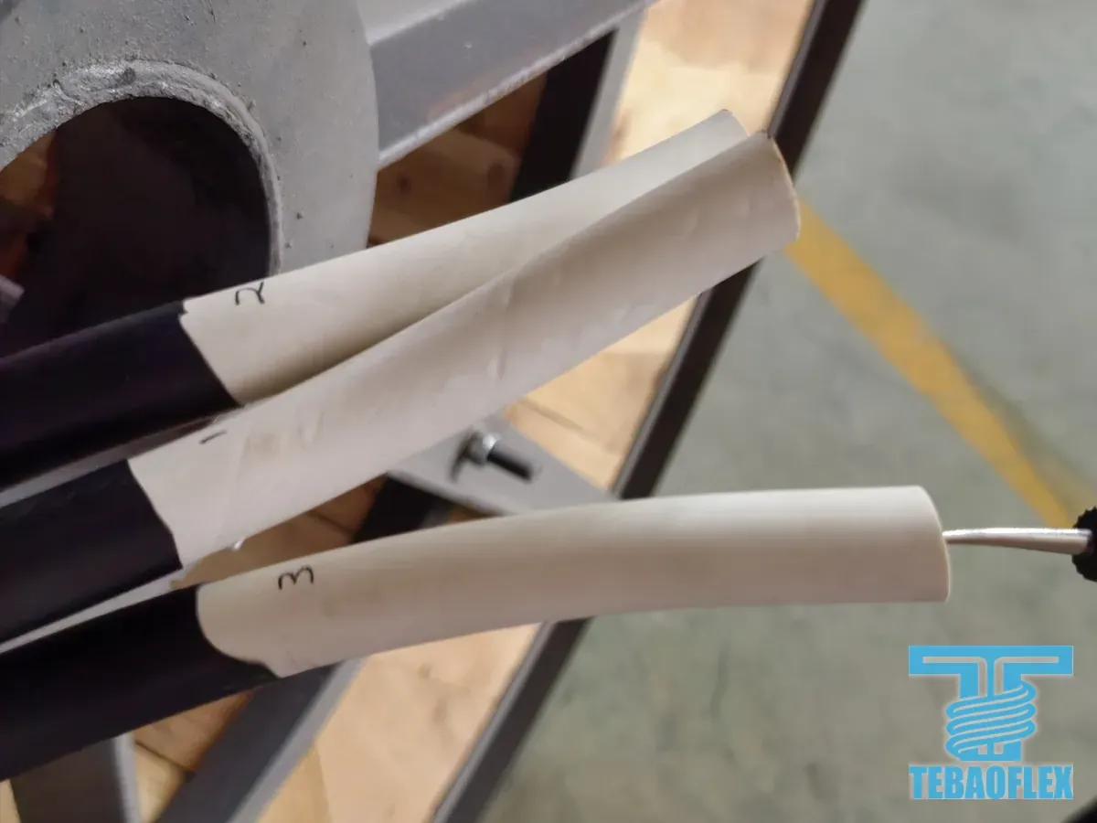 Three white-insulated cores at the end of a cable, printed with the numbers 1, 2 and 3